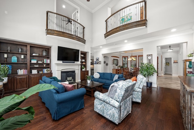 living room featuring a high ceiling, crown molding, and dark wood-type flooring