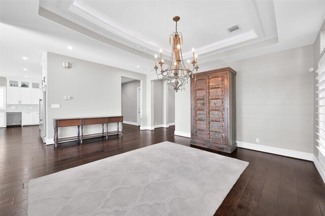 unfurnished dining area featuring recessed lighting, a raised ceiling, visible vents, wood-type flooring, and baseboards