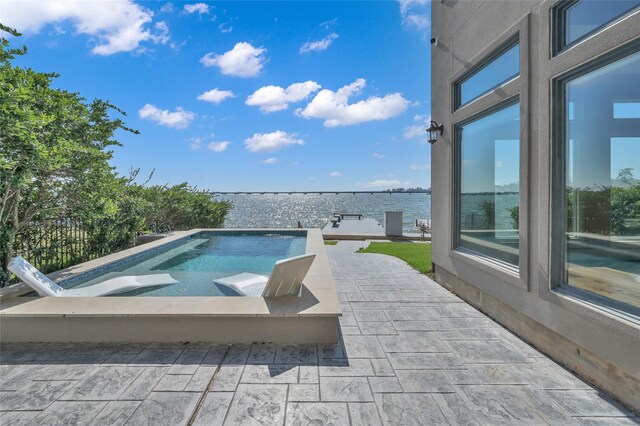 outdoor pool featuring a patio area and a water view