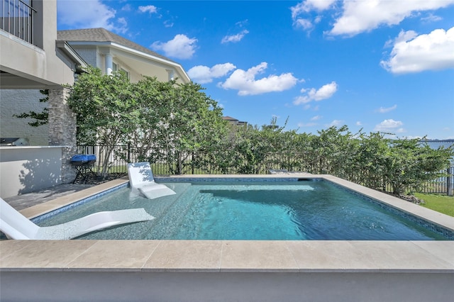 view of swimming pool with fence, a fenced in pool, and a grill