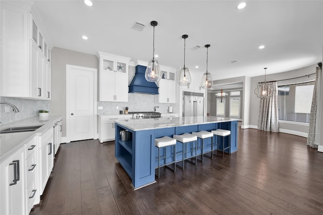 kitchen featuring open shelves, custom range hood, visible vents, a sink, and stainless steel built in refrigerator