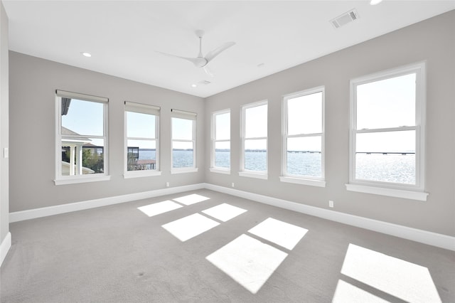 empty room with a ceiling fan, carpet, visible vents, and baseboards