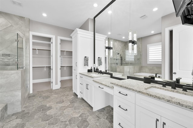 16434 Clear Water Cir, Montgomery, TX 77356 - full bath with a shower stall, a walk in closet, vanity, stone finish flooring, and recessed lighting