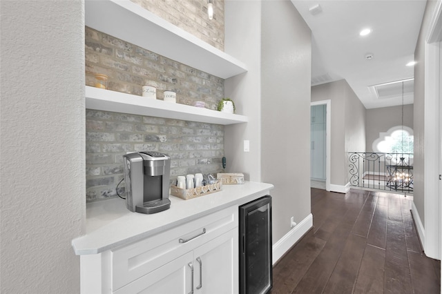 bar with beverage cooler, baseboards, decorative backsplash, dark wood-style floors, and an inviting chandelier