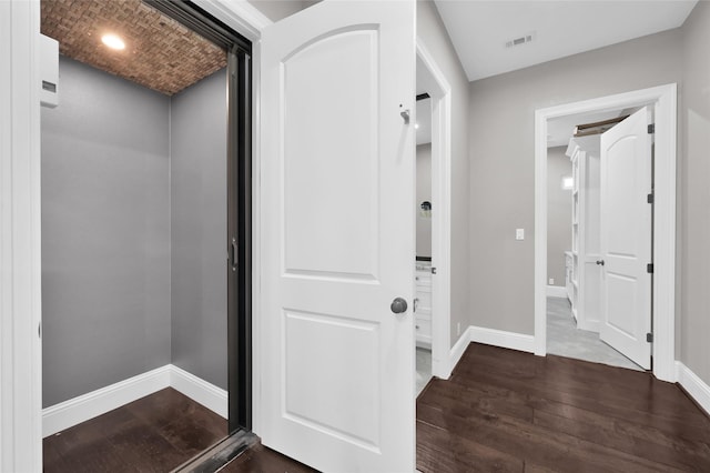 foyer with dark wood-style flooring, visible vents, and baseboards