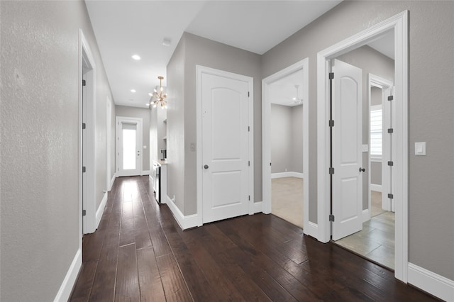 hall with dark wood-style floors, baseboards, a chandelier, and recessed lighting