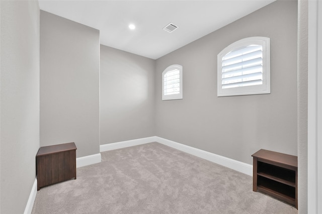 carpeted empty room with visible vents and baseboards