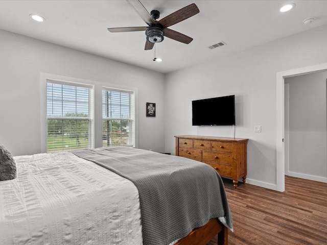 bedroom with dark hardwood / wood-style flooring and ceiling fan