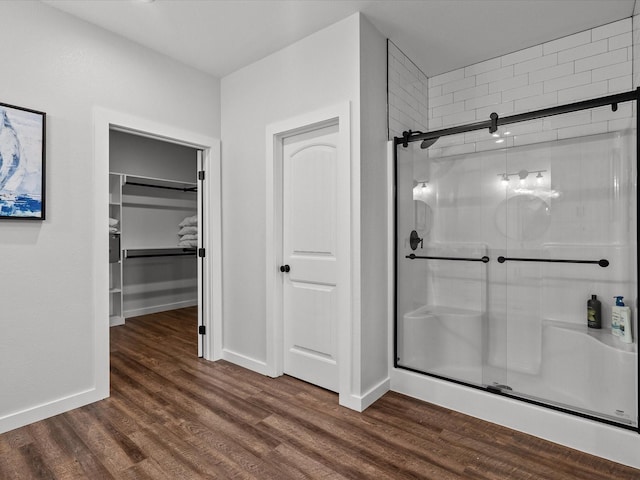 bathroom featuring hardwood / wood-style flooring and walk in shower