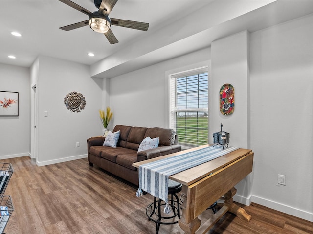 living room featuring wood-type flooring and ceiling fan