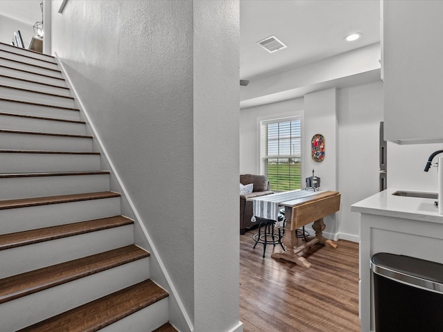 stairway with hardwood / wood-style flooring and sink