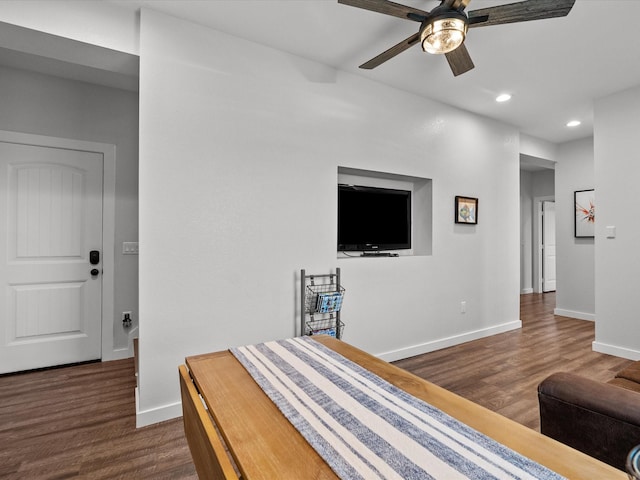 living room featuring dark wood-type flooring and ceiling fan