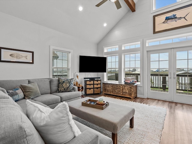 living room with ceiling fan, light hardwood / wood-style flooring, high vaulted ceiling, and beamed ceiling