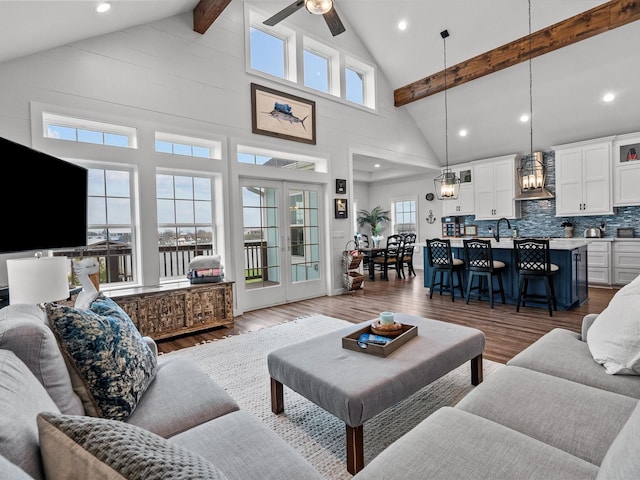 living room with hardwood / wood-style flooring, ceiling fan, high vaulted ceiling, french doors, and beamed ceiling