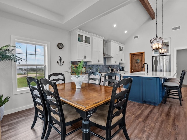 dining area with sink, high vaulted ceiling, a notable chandelier, dark hardwood / wood-style flooring, and beamed ceiling