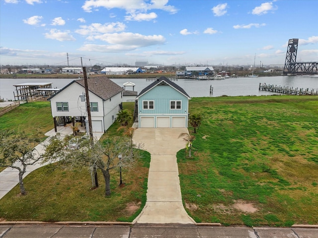 view of front of property featuring a garage, a water view, and a front yard