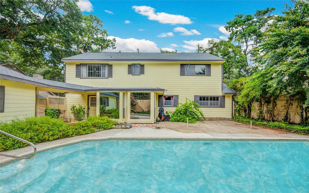 back of property featuring a fenced in pool and a patio area