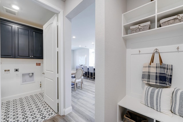 laundry area with baseboards, visible vents, cabinet space, light floors, and electric dryer hookup