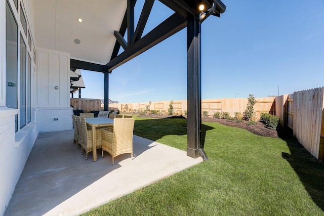 view of yard featuring outdoor dining space, a patio, and fence