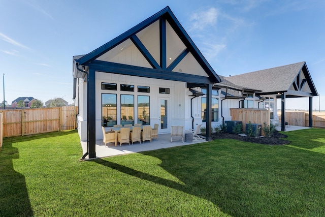 rear view of property with cooling unit, a lawn, and a fenced backyard