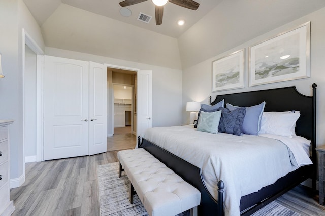 bedroom featuring lofted ceiling, visible vents, a ceiling fan, light wood-type flooring, and a closet