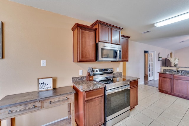 kitchen with light tile patterned flooring, appliances with stainless steel finishes, and sink