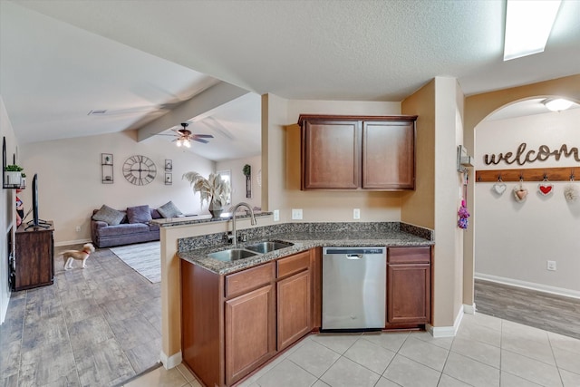 kitchen featuring lofted ceiling with beams, dishwasher, sink, light tile patterned floors, and a textured ceiling