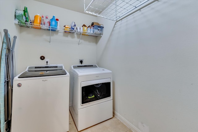 clothes washing area featuring washing machine and clothes dryer and light tile patterned floors