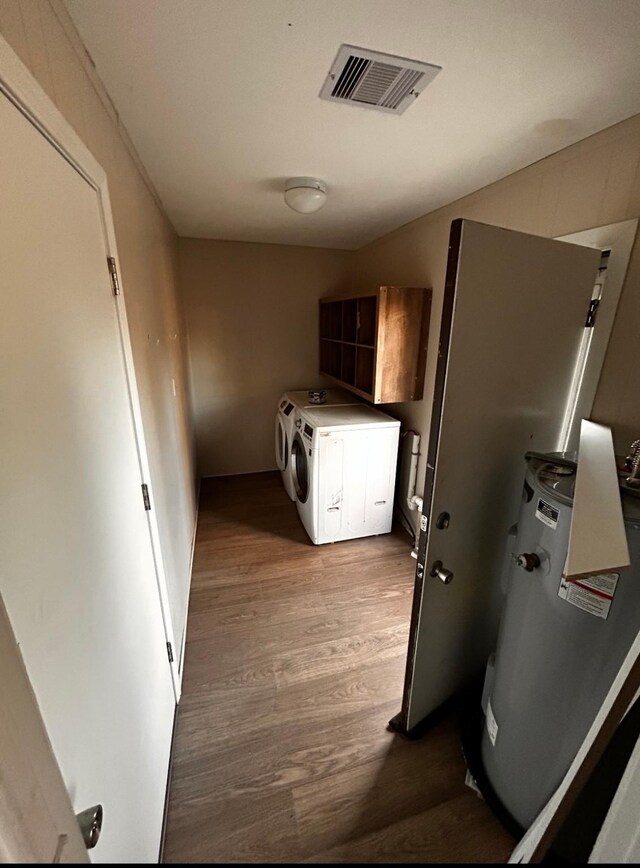 214 Gulf Dr, West Columbia, TX 77486 - clothes washing area featuring cabinets, washing machine and dryer, and light hardwood / wood-style floors