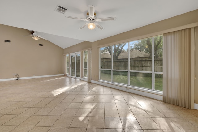 spare room featuring ceiling fan, a healthy amount of sunlight, vaulted ceiling, and light tile patterned floors