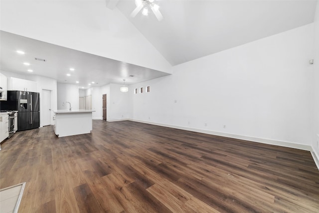 unfurnished living room with ceiling fan, dark wood-type flooring, and high vaulted ceiling