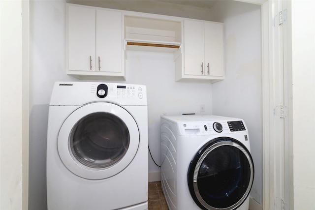 clothes washing area with washer and clothes dryer and cabinets