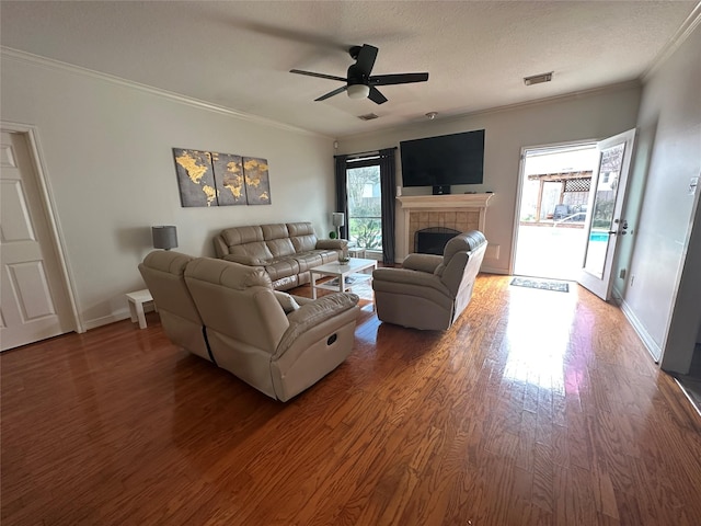 1723 Park Ridge Dr, Katy, TX 77450 - living area featuring crown molding, wood finished floors, baseboards, ceiling fan, and a tiled fireplace