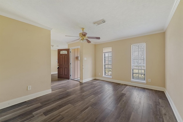 spare room with crown molding, dark wood-type flooring, ceiling fan, and a textured ceiling