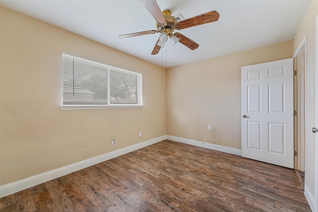 empty room with dark hardwood / wood-style floors and ceiling fan