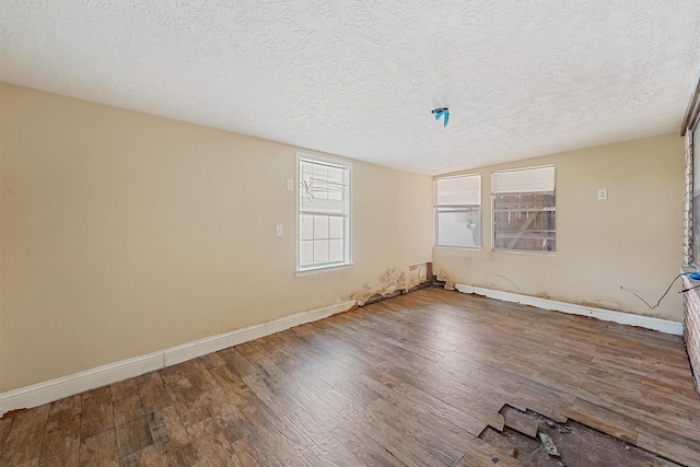 unfurnished room featuring hardwood / wood-style flooring and a textured ceiling