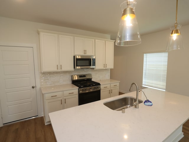 8026 Kay Harbor Dr, Cypress, TX 77433 - kitchen with appliances with stainless steel finishes, a sink, a kitchen island with sink, white cabinetry, and tasteful backsplash