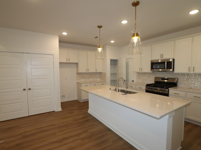 8026 Kay Harbor Dr, Cypress, TX 77433 - kitchen with stainless steel appliances, a sink, white cabinetry, dark wood finished floors, and a center island with sink