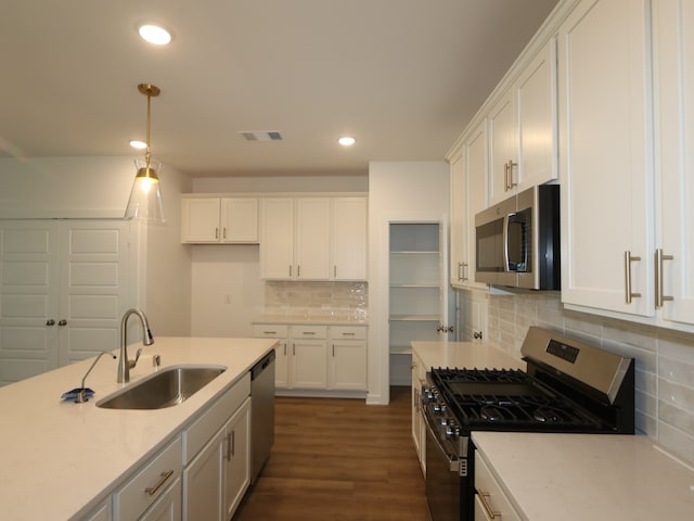 8026 Kay Harbor Dr, Cypress, TX 77433 - kitchen featuring stainless steel appliances, a sink, white cabinets, light countertops, and backsplash