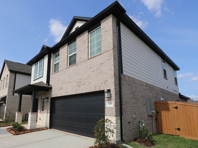 8026 Kay Harbor Dr, Cypress, TX 77433 - view of side of home with an attached garage, brick siding, concrete driveway, and a gate