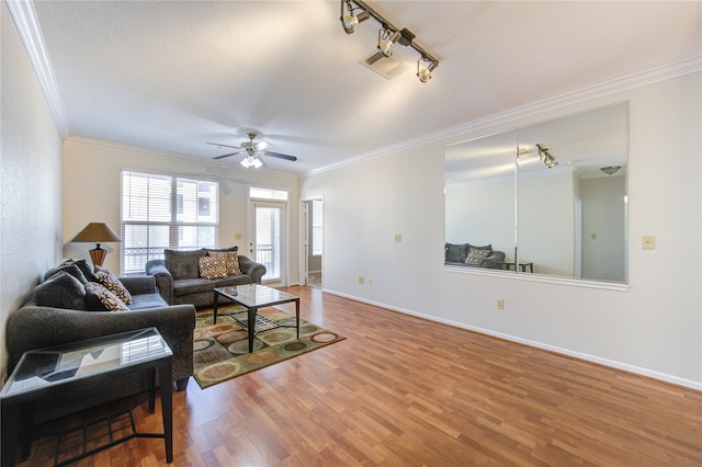 living room featuring hardwood / wood-style flooring, ornamental molding, rail lighting, and ceiling fan