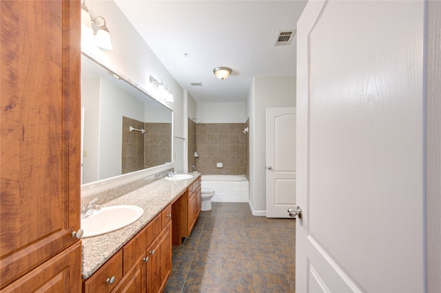 full bathroom with vanity, tiled shower / bath combo, and toilet