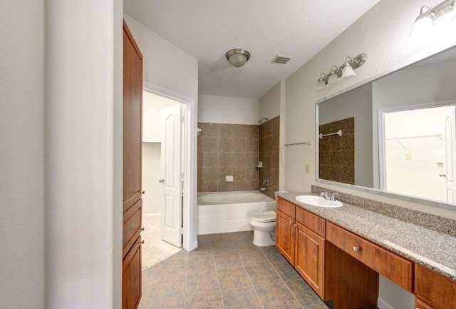 full bathroom with tiled shower / bath combo, vanity, and toilet