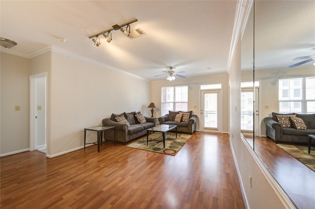 living room with wood-type flooring, ornamental molding, and ceiling fan