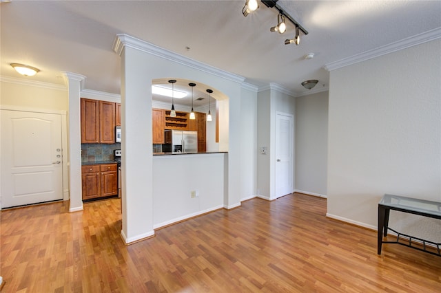 unfurnished living room featuring crown molding and light wood-type flooring