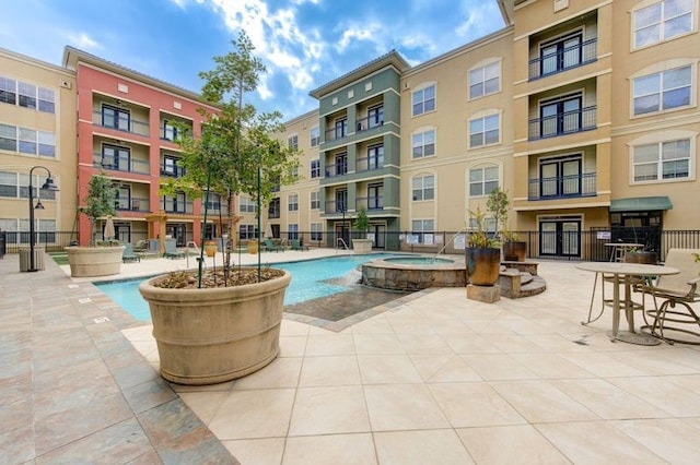 view of swimming pool featuring a community hot tub and a patio