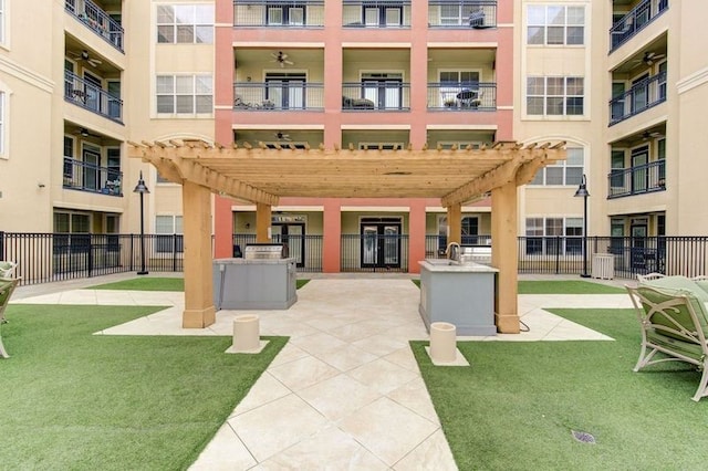 view of community with a yard, sink, and a pergola