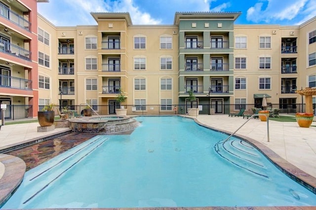 view of swimming pool featuring pool water feature, a patio area, and a community hot tub