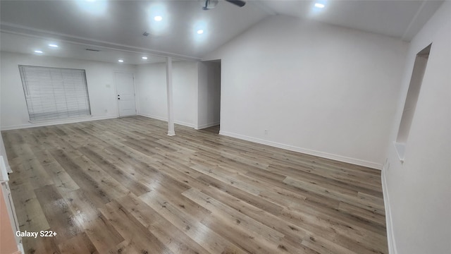 unfurnished room featuring lofted ceiling, recessed lighting, wood finished floors, and baseboards