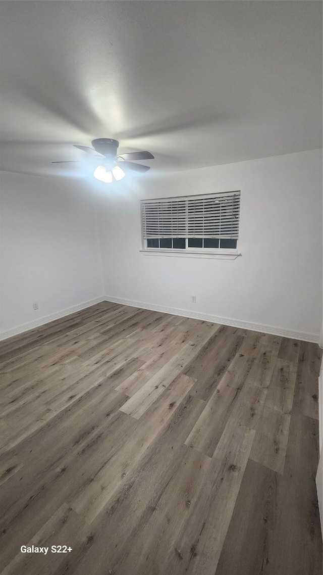 empty room featuring baseboards, a ceiling fan, and wood finished floors